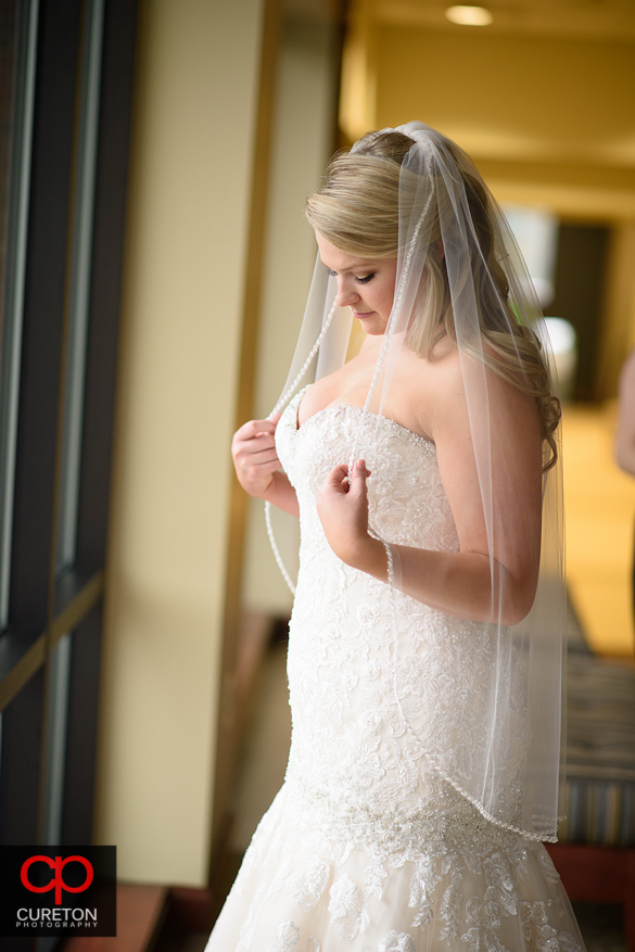 Bride standing in window light.