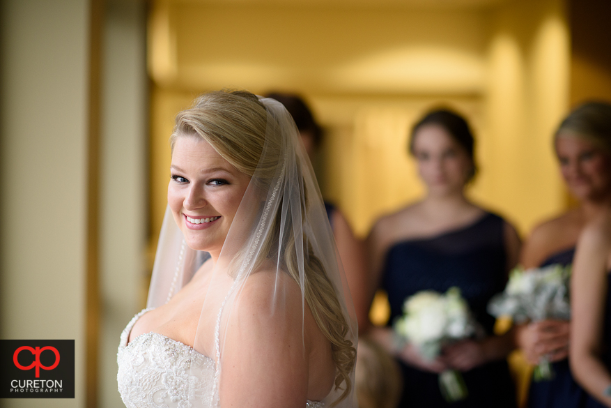 Bride standing in window light.