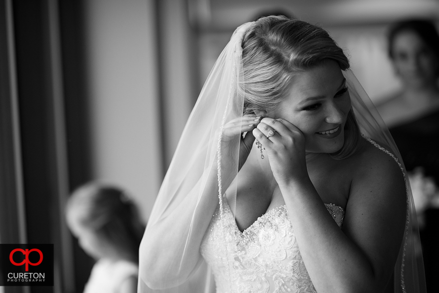 Bride standing in window light.