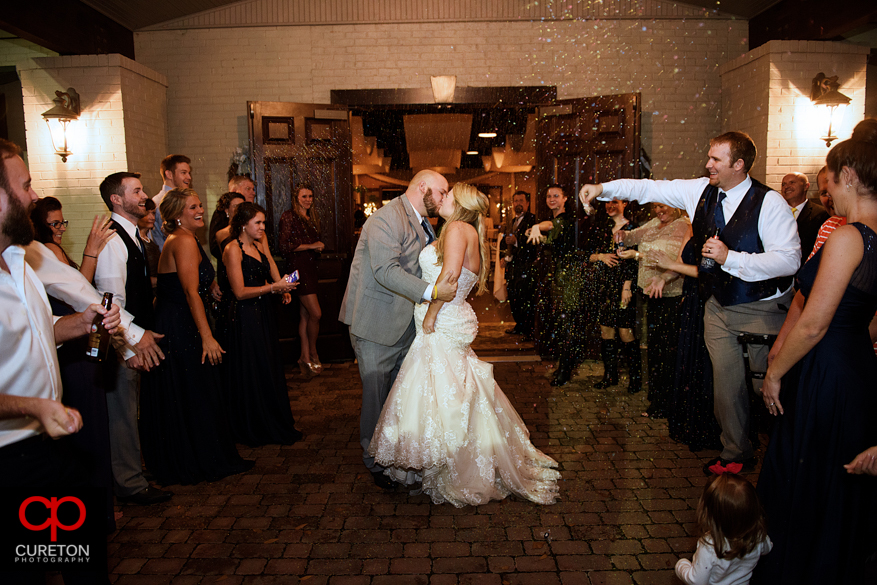 Bride and groom leave though confetti.