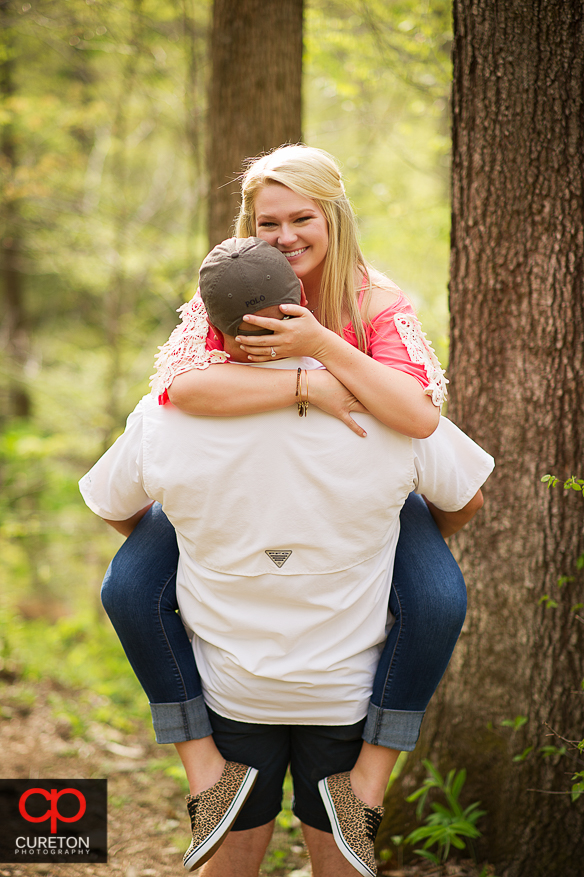 A bride is carried by her groom to be during their Pearson's Falls engagement session.