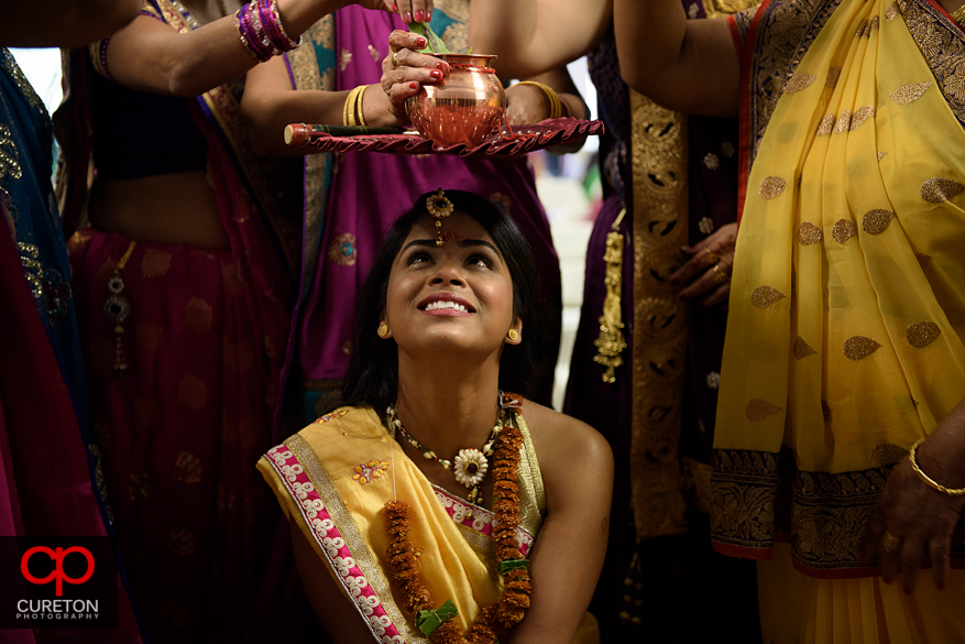 Indian bride gets the pithi put on her face before her wedding.