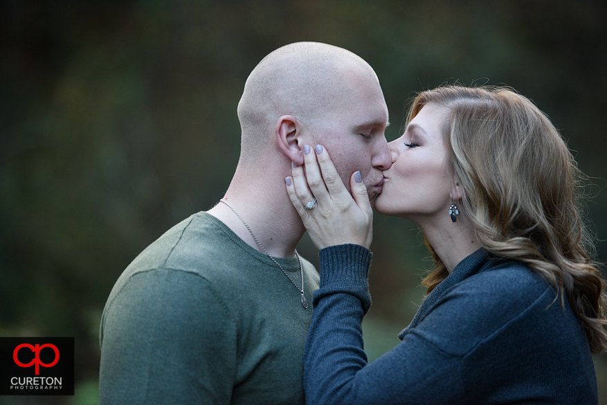 Enagde cople kissing.