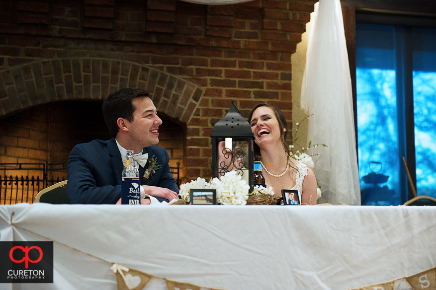 Couple laughing during toasts.