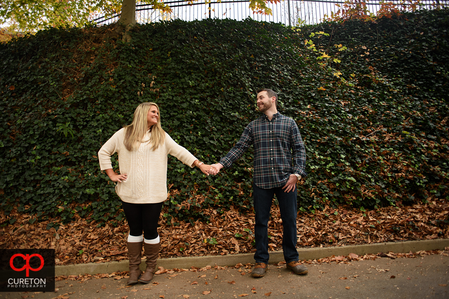 Cute couple standing in front of a wall of ivy.