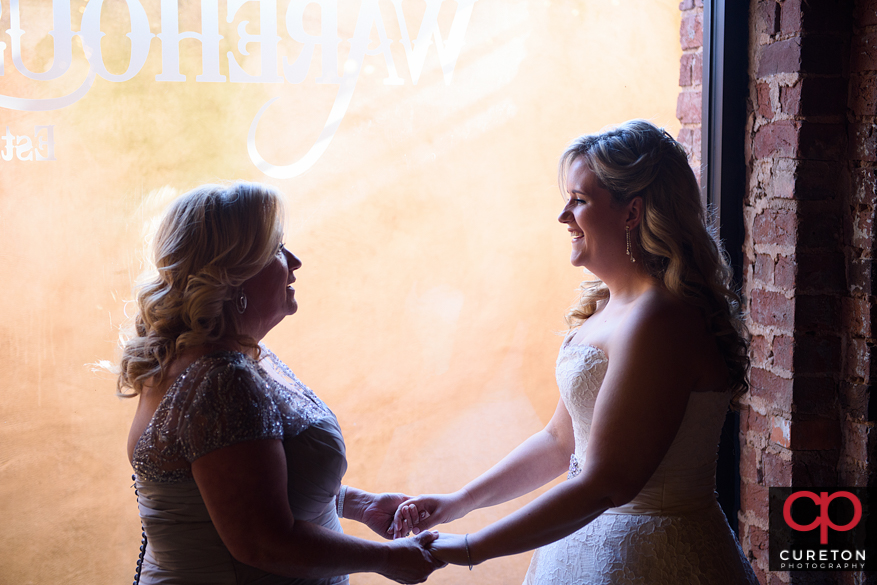 Bride and mom standin in the window sharing a moment.