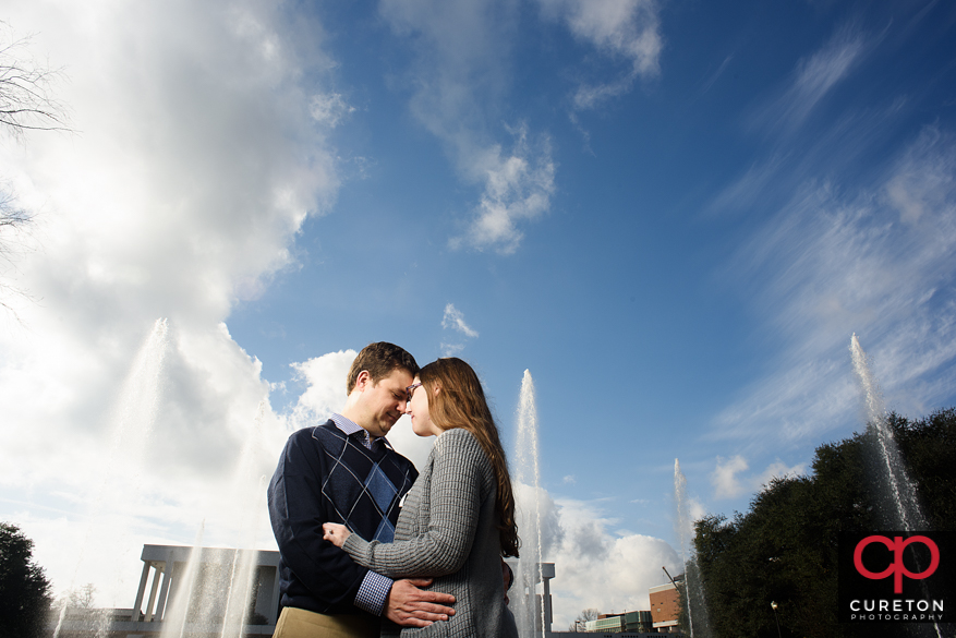 Couple in front of a fountain during a Clemson University engagement session.