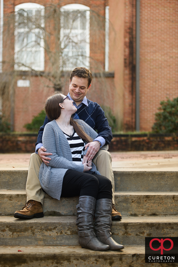 Couple gazing in each others eyes on the steps on Clemson University.