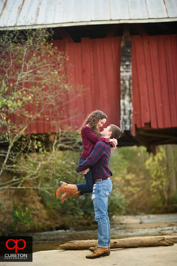 Newly engaged couple celebrating the proposal at Campbell's covered Bridge in Greer,SC.