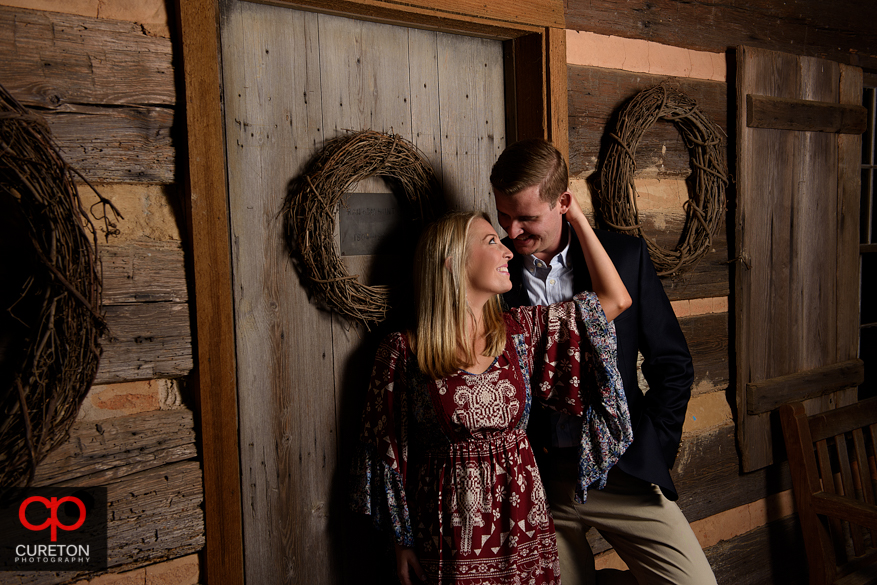 Couple at the Hunt cabin at a Botanical Garden engagement session in Clemson,SC.