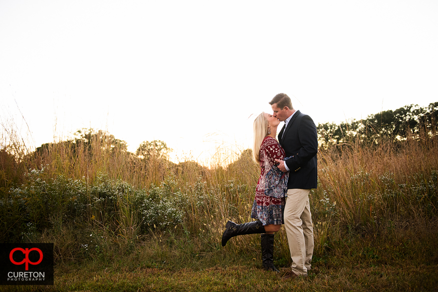 Couple kissing at sunset at a Botanical Garden engagement session in Clemson,SC.