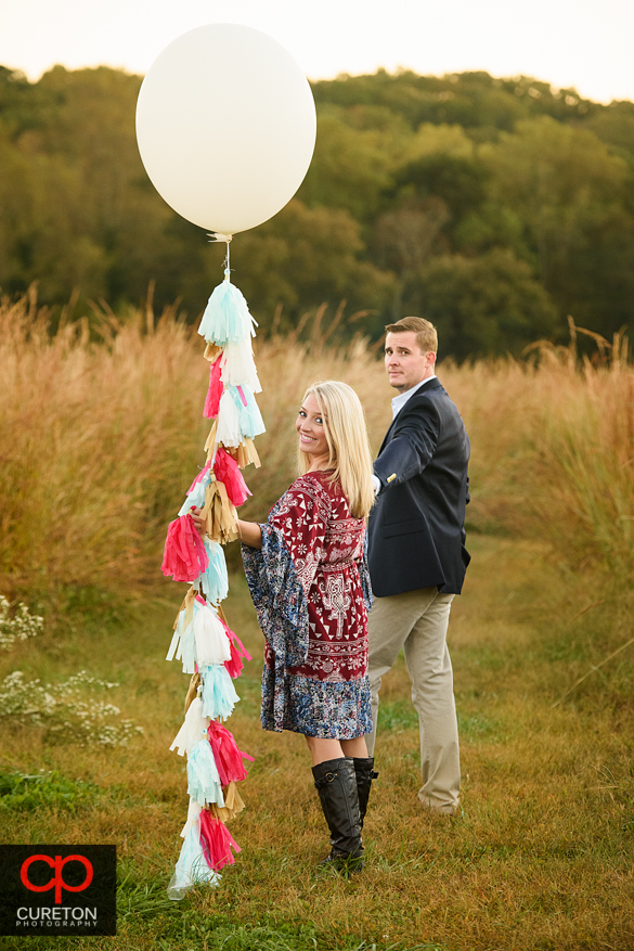 Couple holding a balloon at a Botanical Garden engagement session in Clemson,SC.