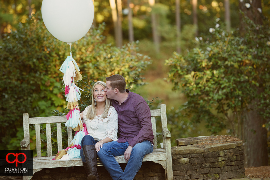 Groom kissing his fiancee.