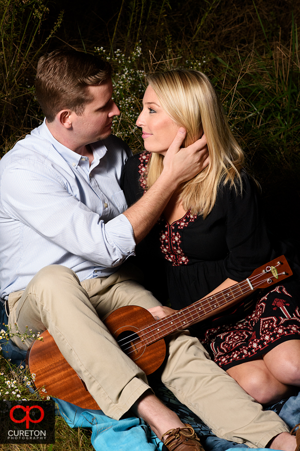 Girl with her fiancee and his guitar at a Botanical Garden engagement session in Clemson,SC..