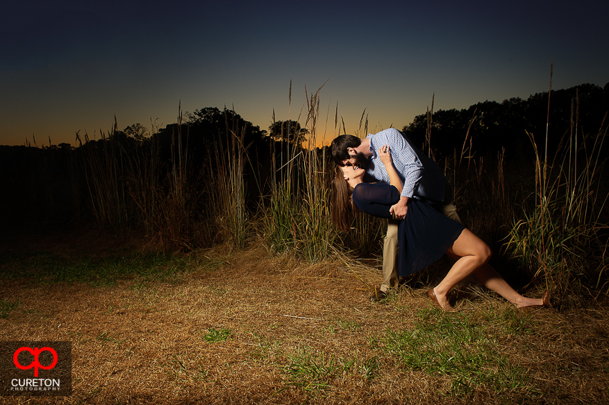 Couple dips at sunset during their Botanical Gardens engagement session in Clemson,SC..