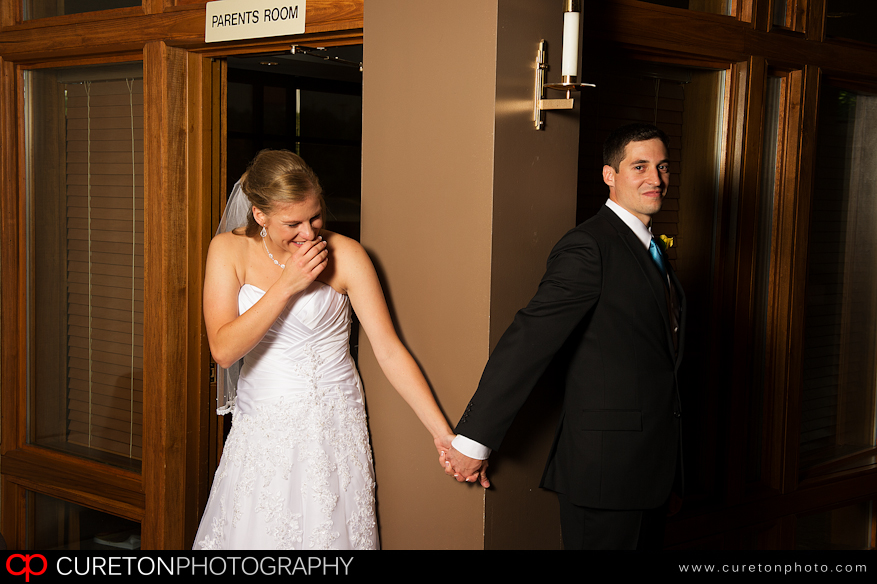 Bride and Groom before wedding on each side of a door.