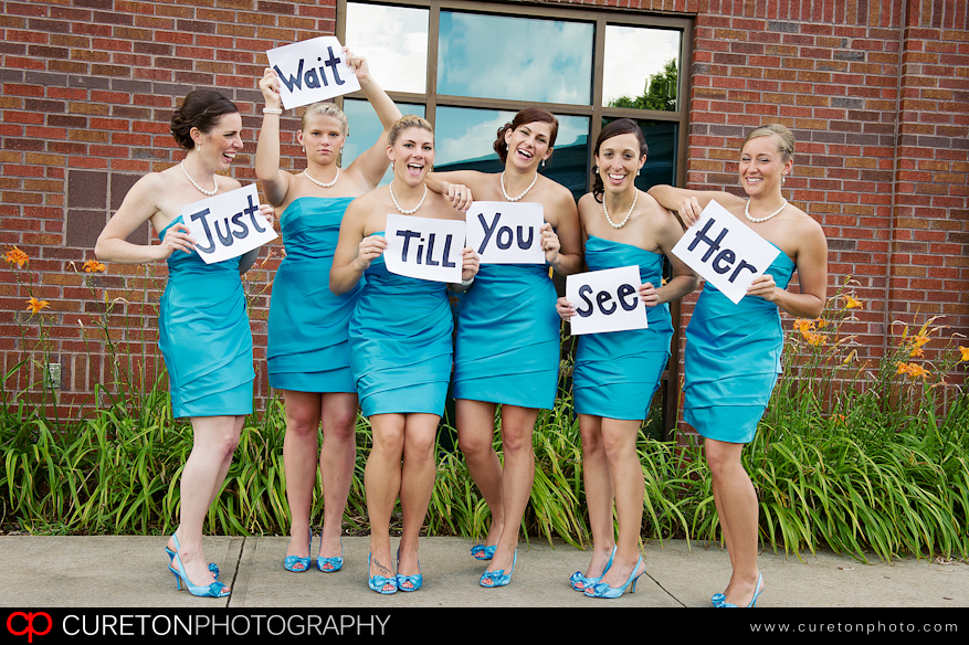 Bridesmaids holing a sign