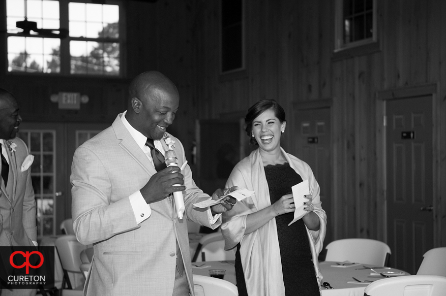 Groom and bride look on as the best man and maid of honor toast the,.
