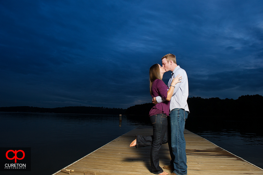 A couple kissing on the dock at the Clemson University rowing complex on Lake Hartwell.