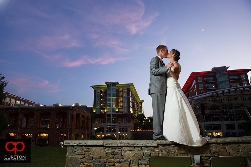 Married Couple kissing in downtown Greenville,SC outside their Huguenot Loft reception.