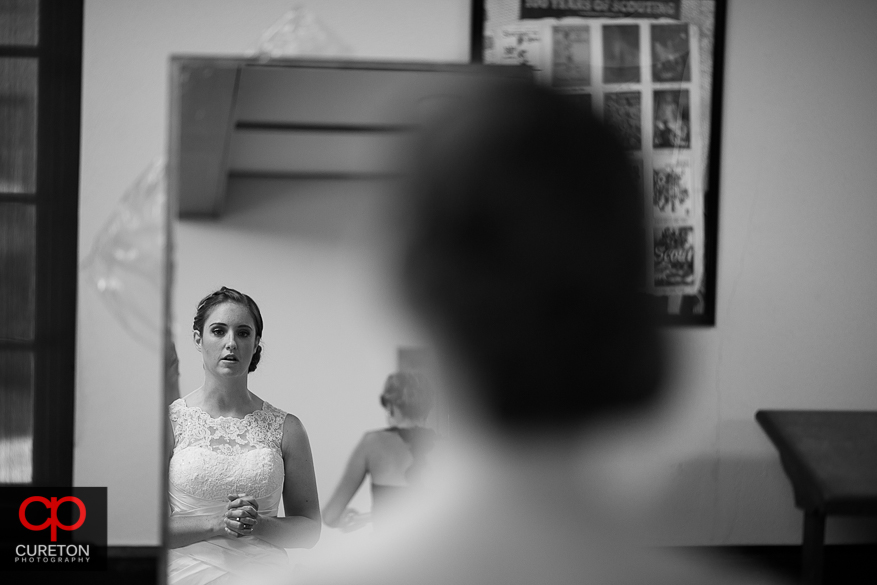 The bride looking into a mirror.