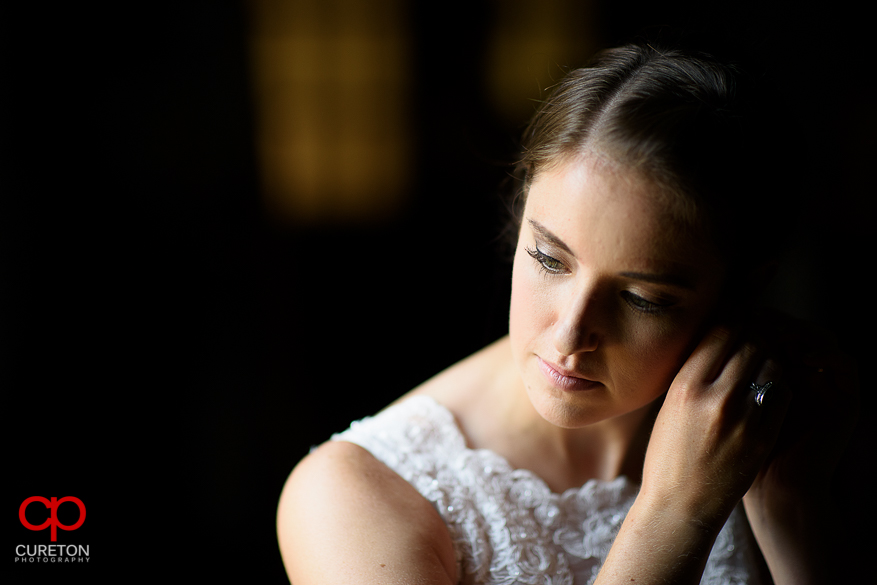 The bride putting on her earrings.