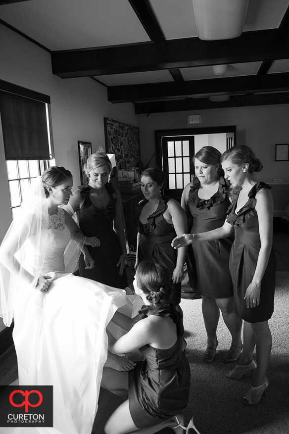 The bridesmaids all helping the bride get ready.