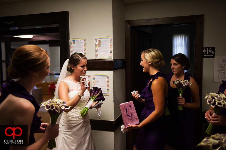 The bride cries as she receives her groom's gift.