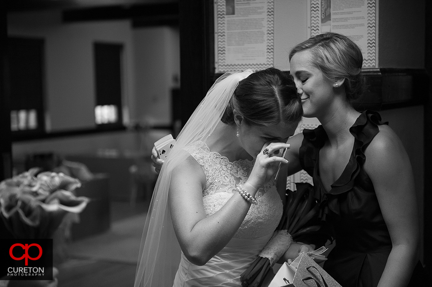 The bride cries as she looks at the groom's gift.