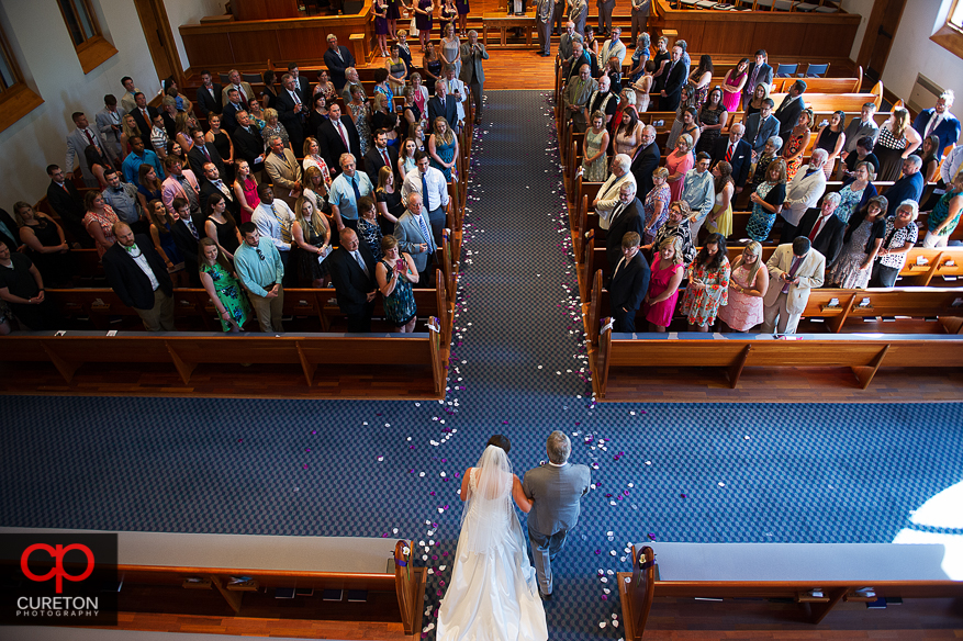 The bride and her father walk down the aisle.