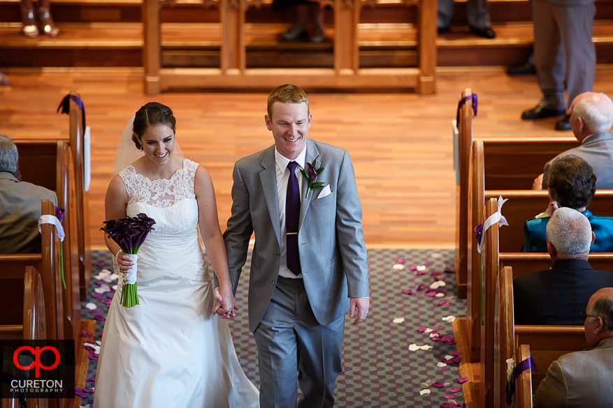 The bride and groom walk down the aisle.