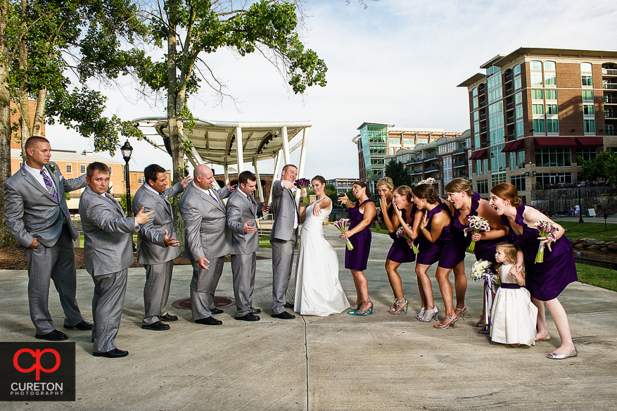 The wedding party stands in awe of the rock on the bride's hand.