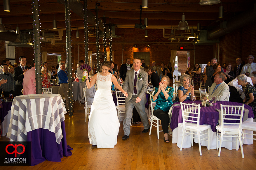 The bride and groom enter their reception.