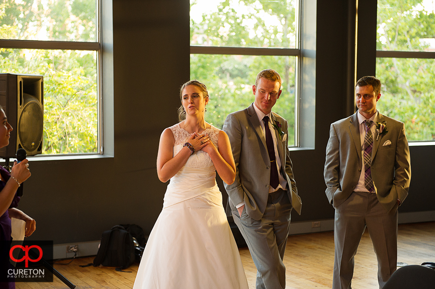 The bride and groom watch as they are toasted.