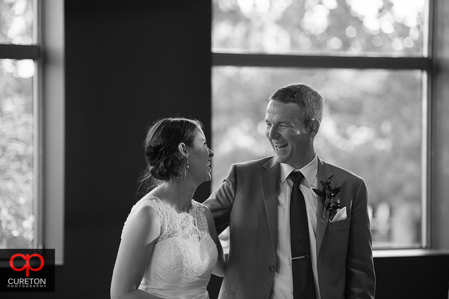 Bride and groom laughing together.