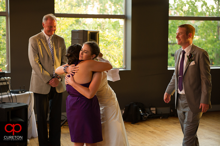 The bride hugs her bridesmaid.