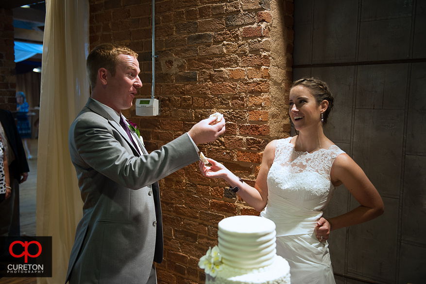 The bride and groom cutting a beautiful cake by Kathy and Company.