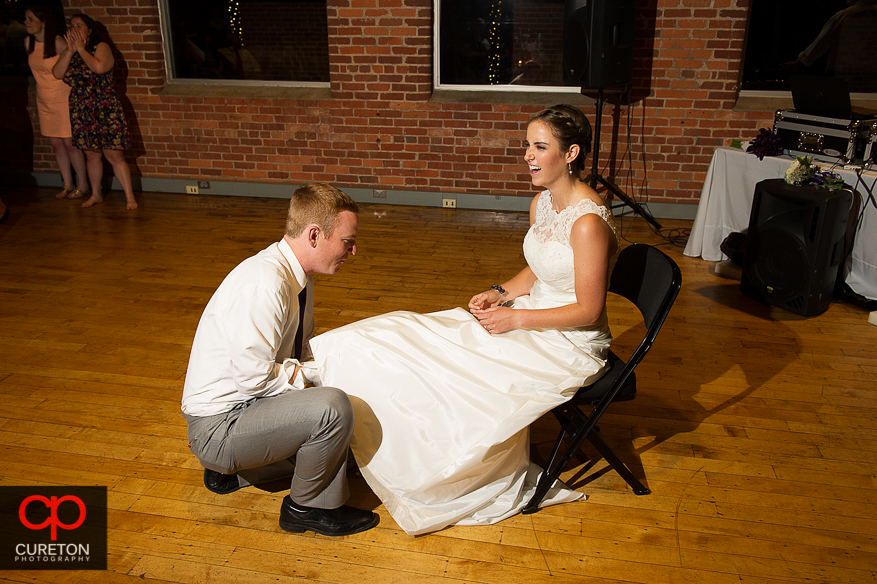 Groom taking off the garter.