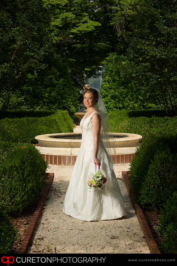 Bride standing in front of fountain.