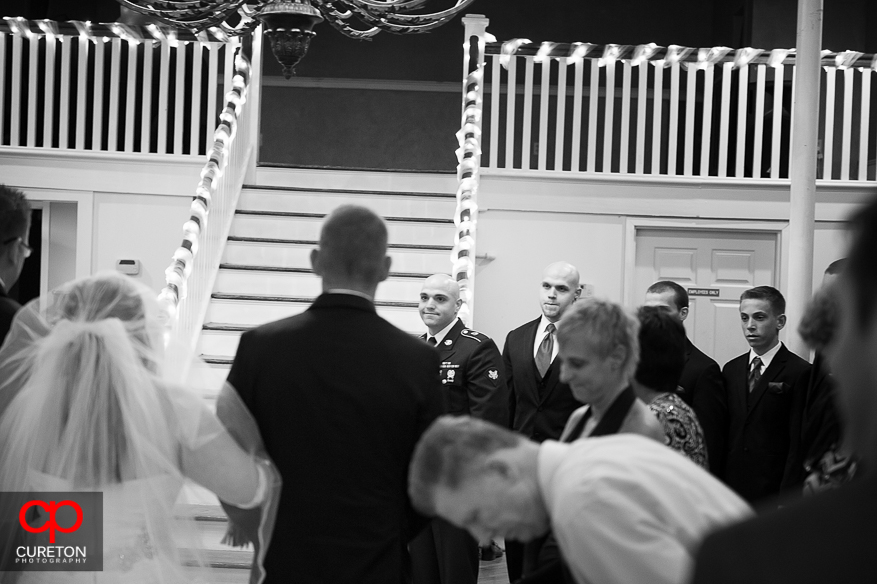 Groom sees his bride for the first time walking down the aisle.