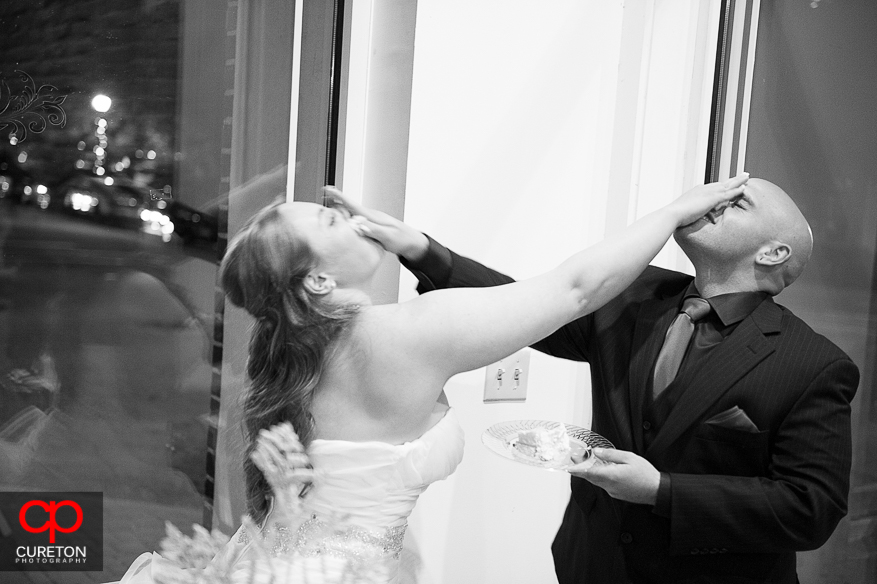 Bride and Groom smearing cake on each others face at their wedding at The Davenport in Greer,SC.