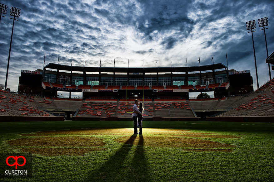 A couple kissing on the football field at Death Valley in Clemson during an engagement photo session. 