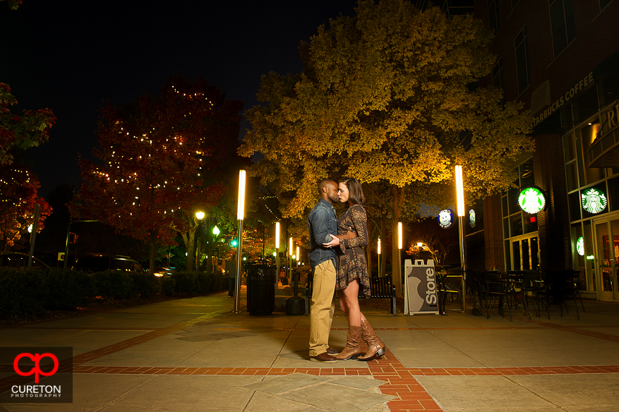 Couple kissing on Main St. during their downtown Greenville,SC engagement session.