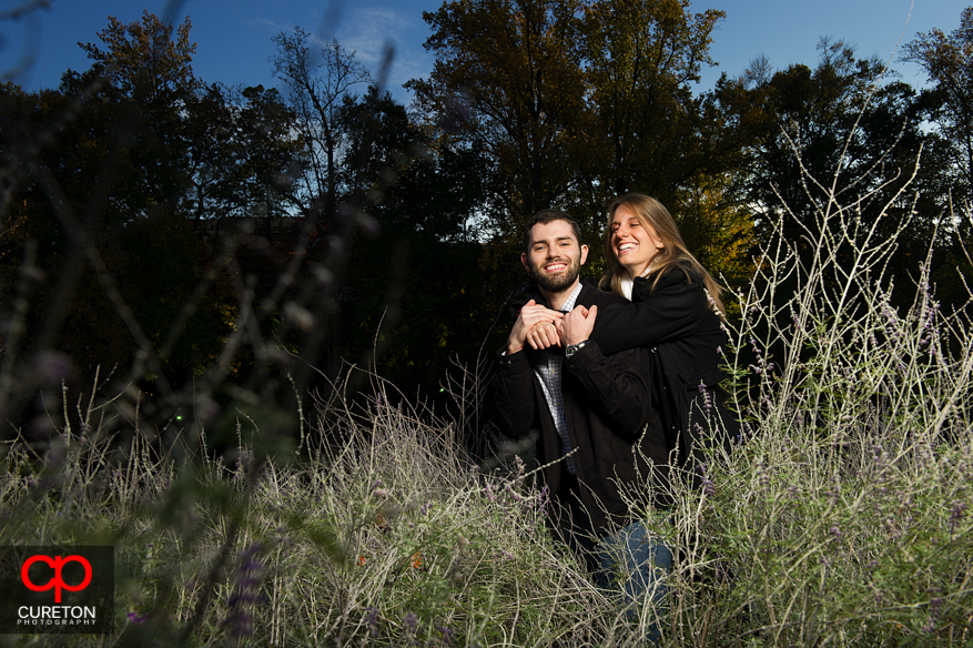 A couple standing in the tall grass at Falls Park.