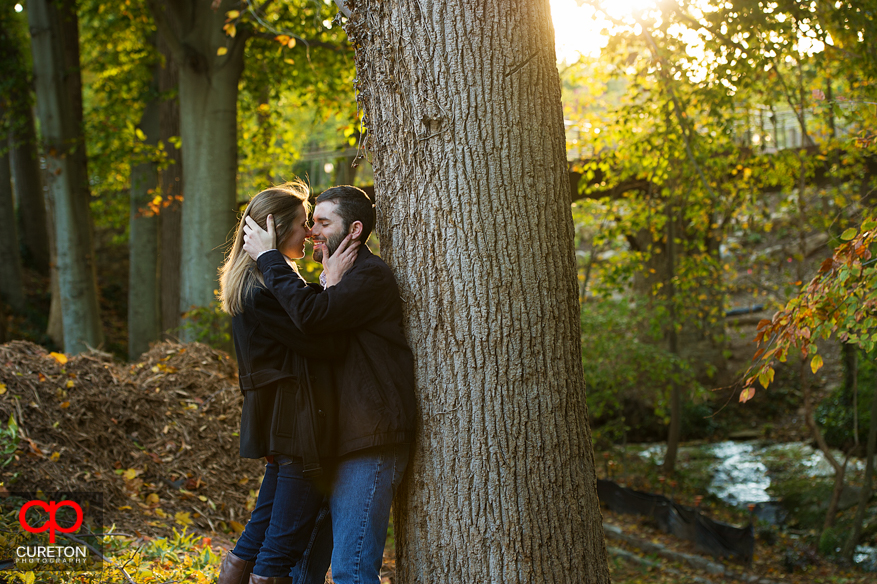 A couple standing in beautiful fall foliage during their Falls Park engagement session.