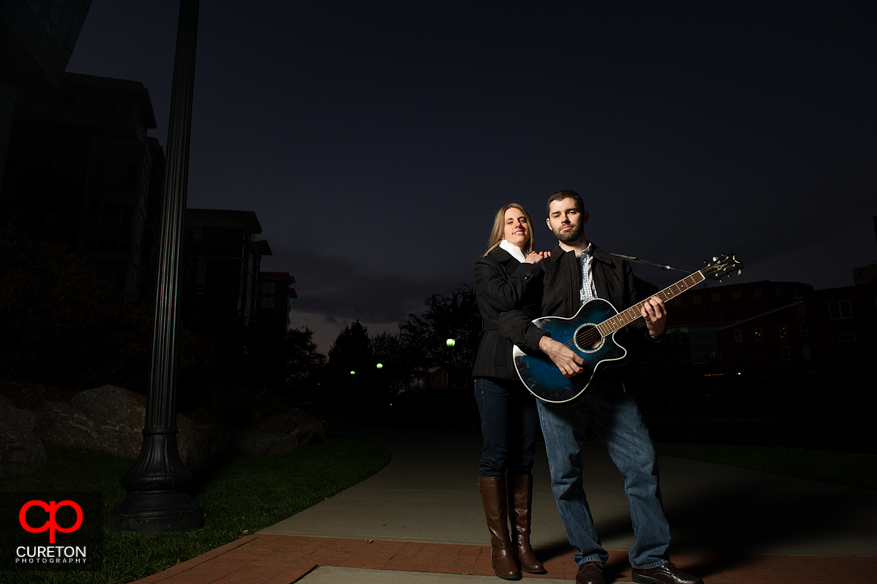 A man, his fiancee, and a guitar at sunset.