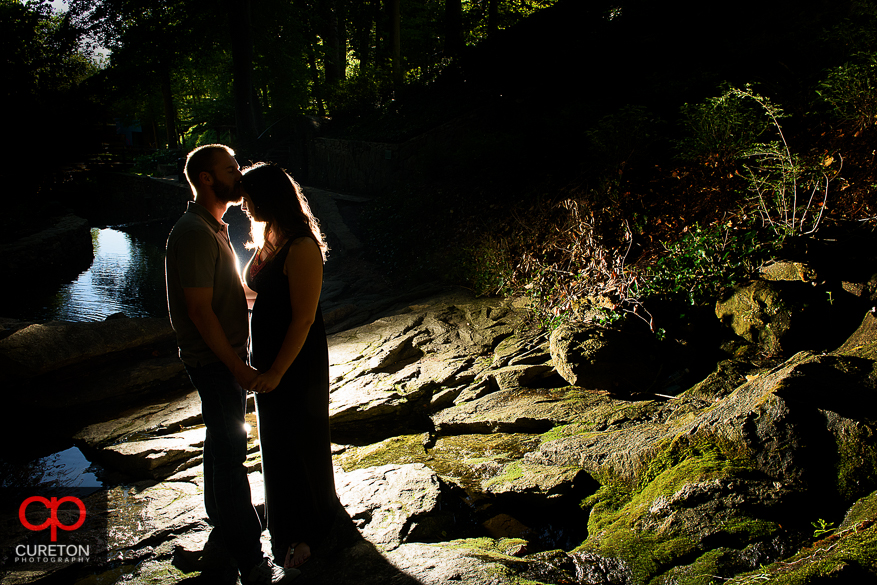 Silhouette of a groom kissing the brides forehead during a pre wedding engagement session at Falls Park on the Reedy in Greenville,SC.