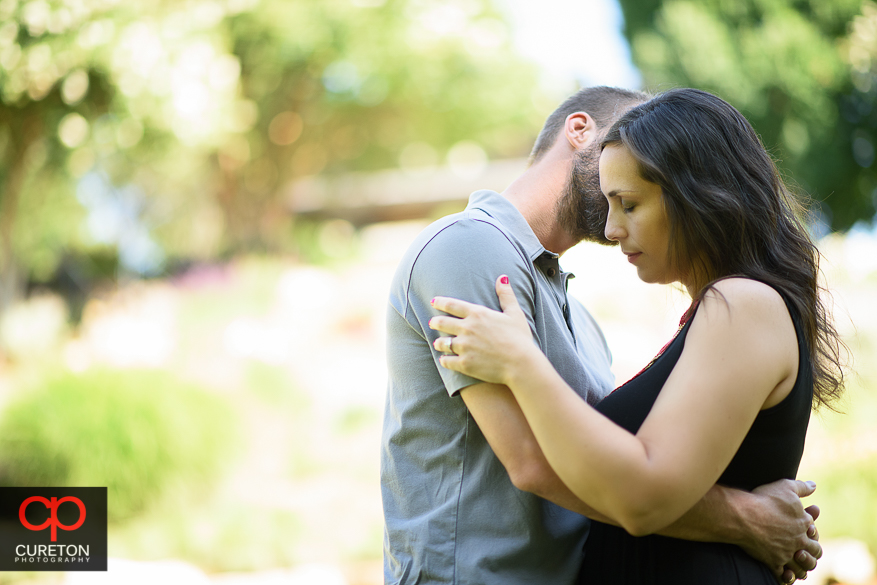 Romantic couple kissing during a pre wedding engagement session at Falls Park on the Reedy in Greenville,SC..