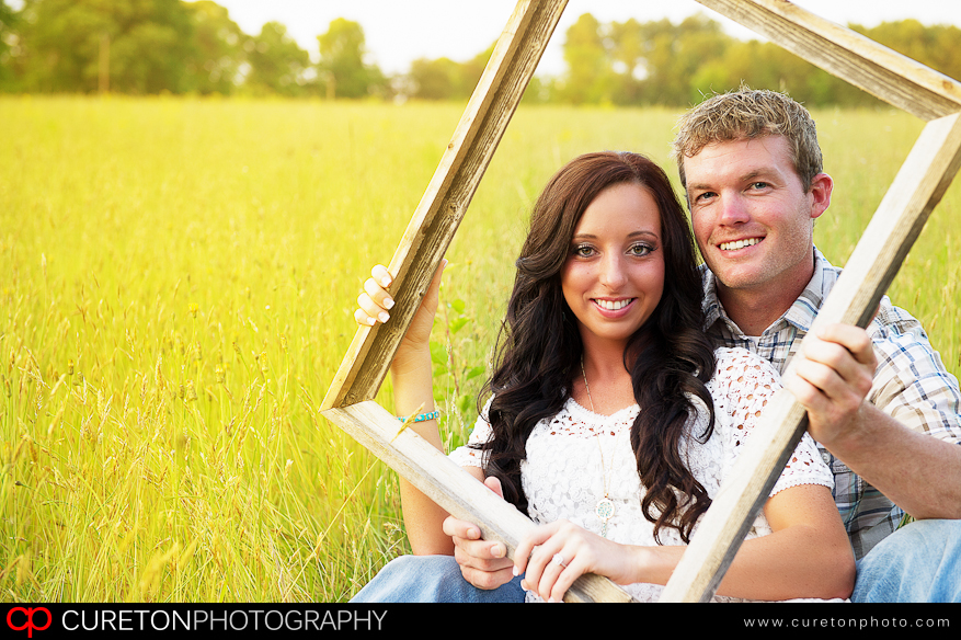 A couple holding a picture frame.