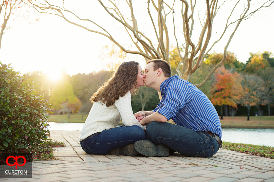 Couple kissing by the lake during their Furman University engagement session.